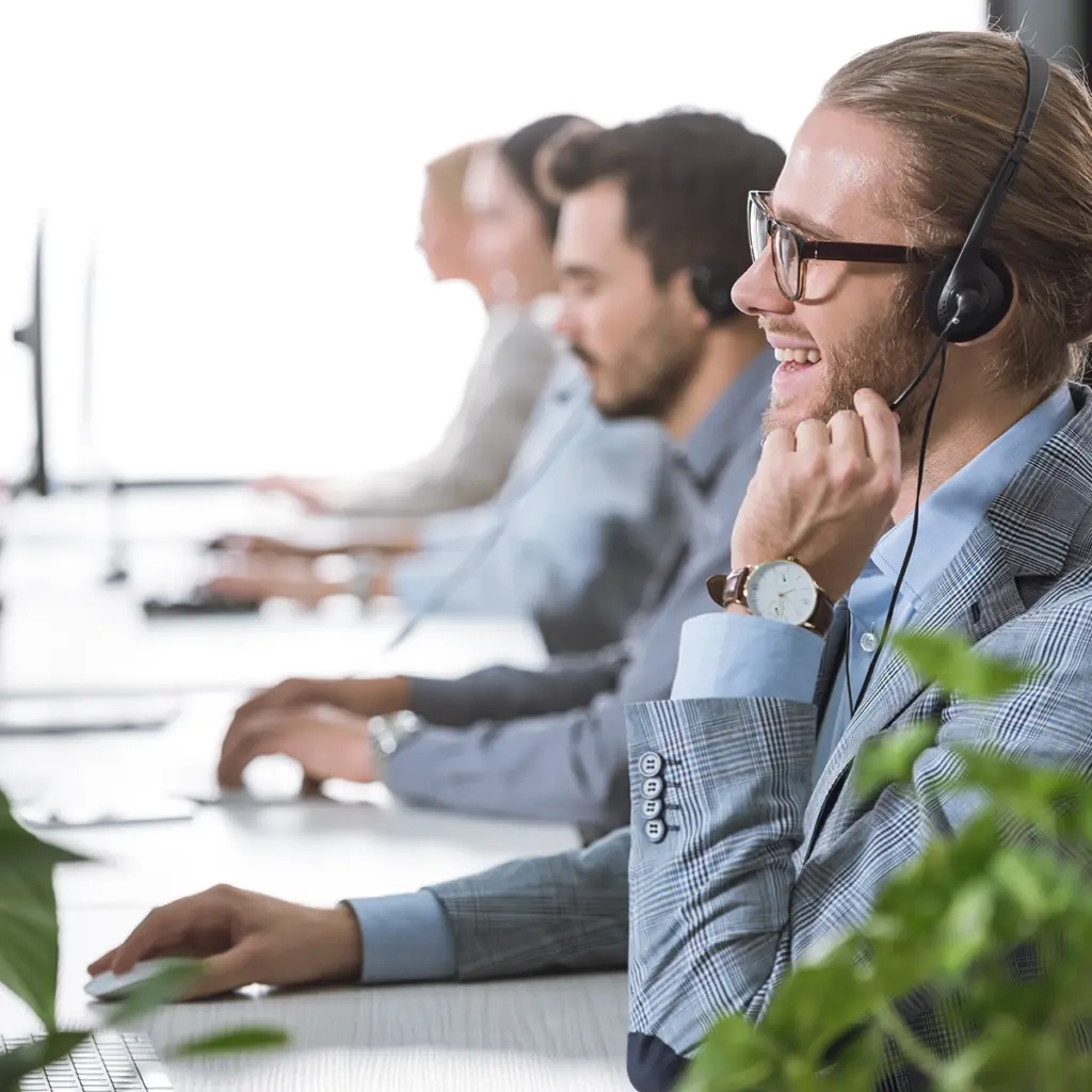 Personer som arbetar med datorer och headset vid IT-support
